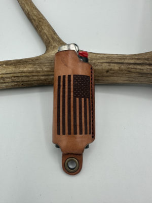 A U.S. Flag has been laser-engraved on this leather Lighter Sleeve resting upon an antler.