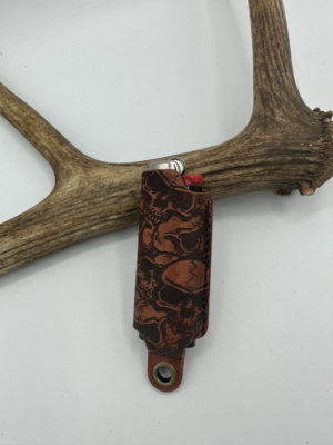 A Classic Leather Lighter Sleeve Skull-patterned. There is an antler in the picture too.